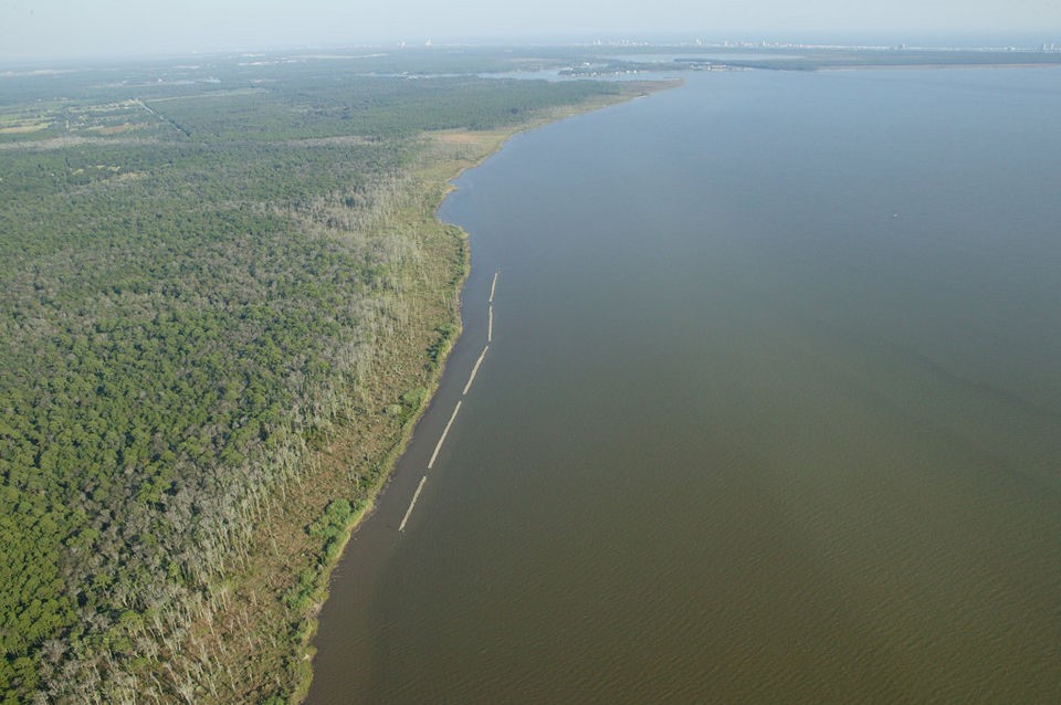 Aerial view of the 2012 Swift Tract living shorelines project. White lines in the water are oyster shell breakwaters (Image: JoeBay Aerials, for The Nature Conservancy). 